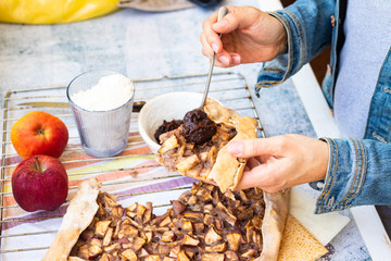 Apple crust tart pie with chocolate cream spread paste and cinnamon. Ingredients. Woman hands
