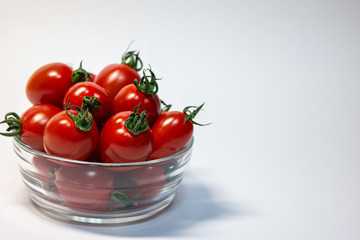 fresh red cherry tomato in round transparent glass and copy space