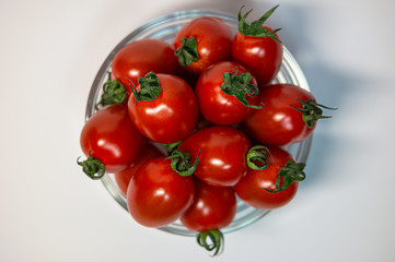 Top view fresh red cherry tomato in a round transparent glass bowl