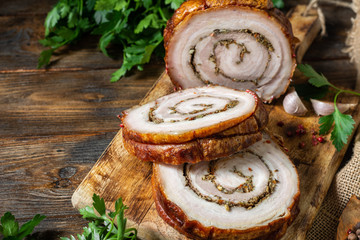 Meatloaf with vegetables and herbs on a wooden Board on a brown wooden table. Baked meat. The view from the top. Rustic style