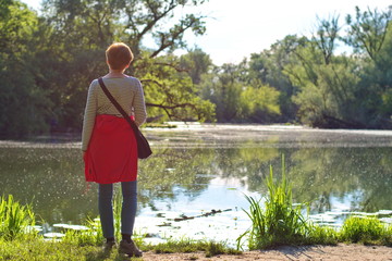 Rear view of senior woman standing on lake shore