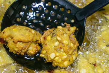 Fried cook of  Batate Vade, Batate Vadey, Fried Dhal Beans Cake or Kuih Vadey closeup. Indian traditional food. Selective focus
