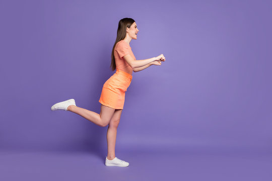 Full body profile photo of pretty lady addicted shopper leading rolling imaginary store trolley wear casual orange striped t-shirt jeans mini skirt isolated pastel purple color background