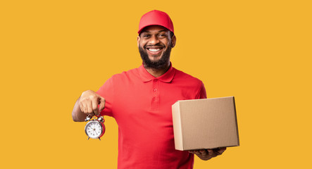 Courier Holding Clock And Box Standing Over Yellow Background, Panorama