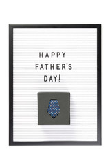 Happy Father's Day text on letter board with boxed dark blue tie isolated on white. Minimal framed text. Father's Day sale mockup template. Copy space