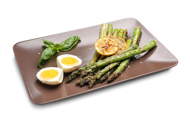 Cooked asparagus with egg and lemon on white background