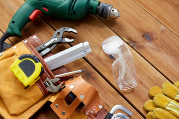 repair, building and carpentry concept - different work tools on wooden boards