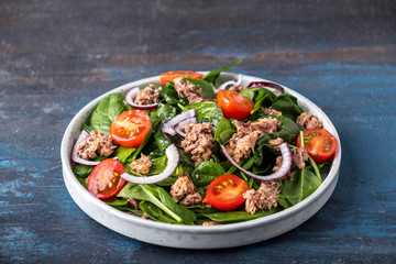 Tuna salad with tomatoes, red onion and spinach. Healthy and diet food concept.