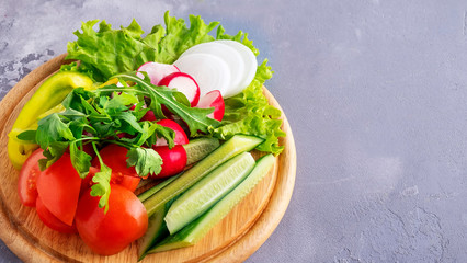Different cuts vegetables on a  wooden board. Copy space