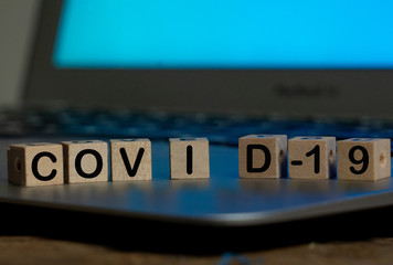 Conceptual Close up image of laptop and COVID-19 written in blocks for stay connected concept.
