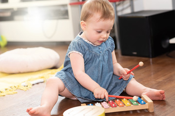 Baby girl playing on a xylophone