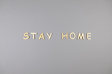 Words stay home made from wooden letters on gray background. Top view