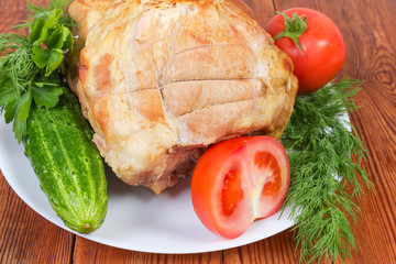 Piece of baked pork on dish with vegetables close-up