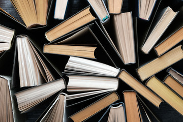 Naklejka premium Old books on wooden vintage background, top view on binding.