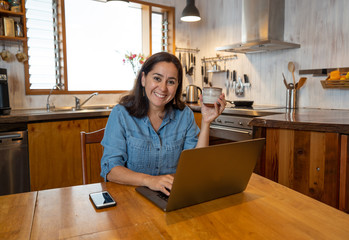 Happy successful young woman on laptop working from home in Coronavirus and New normal concept
