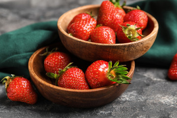 Plates with ripe strawberry on grey background