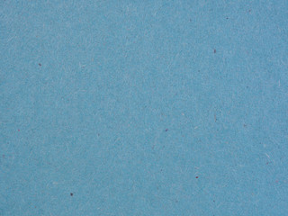 The surface of a sheet of blue or azure gray cardboard. Rough natural paper texture with cellulose fibers. Background or wallpaper. View from above. Macro
