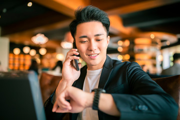 young Business man  Working On Laptop and mobile phone In Coffee Shop