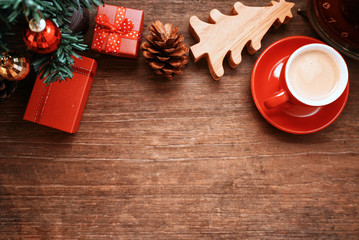 Top lay out gift boxse and pine cone and red coffee cup decorate under chriatmas tree , picture have space for idea.