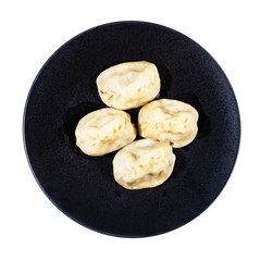 top view of boiled Manti (type of dumpling in turkic cuisine) on black plate isolated on white background