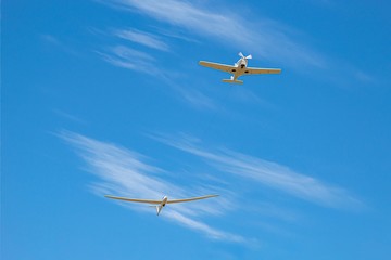 the plane pulls to disperse the glider in the blue sky