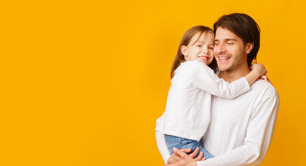 Fototapeta premium Pretty little girl hugging her handsome father