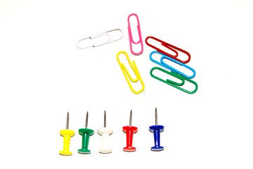 Push pins and paper clips in different colors isolated on white background.
