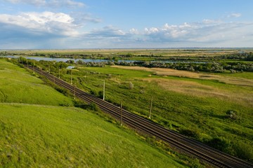 Summer landscape view of the railway on the river bank. Aerial view.