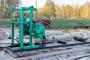 A small sawmill for processing wood in the countryside. Logs of aspen.