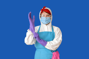 Fototapeta na wymiar Housewife in protective costume wearing gloves on color background