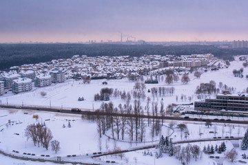 Fototapeta na wymiar top view on a winter city. in the distance you can see pipes from which smoke