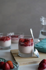 Glass with delicious strawberry panna cotta for breakfast on the kitchen. Tasty italian dessert