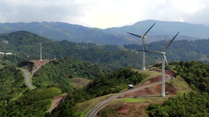 Beautiful cinematic aerial view of the eolian renewable energy wind mild towers in Costa Rica