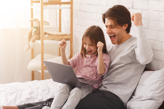 Emotional father and daughter playing computer games