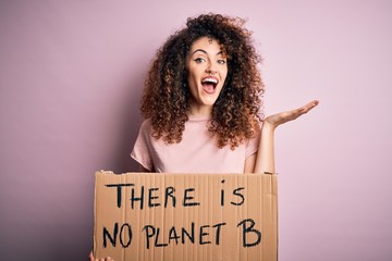 Young beautiful activist woman with curly hair and piercing protesting asking for change planet...