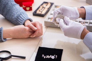 Male jeweler and female client at store