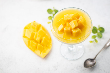 Italian dessert panna cotta with mango in glass on white background