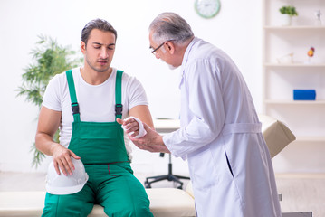 Young male contractor visiting old doctor