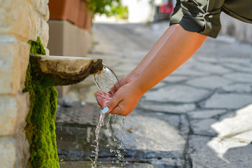 Washing hands in fresh, cold, potable source water on a mountain, Drinking Spring, Wooden Pipe of Fresh Potable, Unpolluted, Natural Spring Water