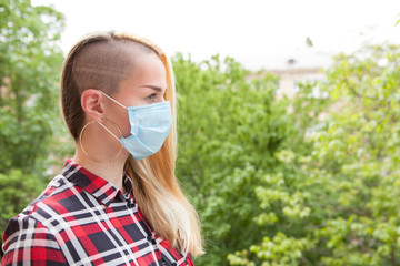 Woman walking in the park, wearing face protective mask, copy space. Health, breathing concept