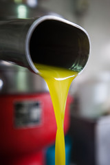 Fresh virgin olive oil pouring after phase of the cold-press factory after the olive harvesting.