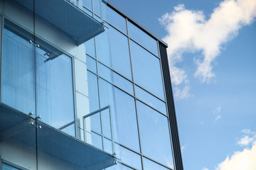 Fototapeta na wymiar Glass building with sky and clouds reflection in windows