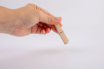 hand holding wooden clothespin isolated on white