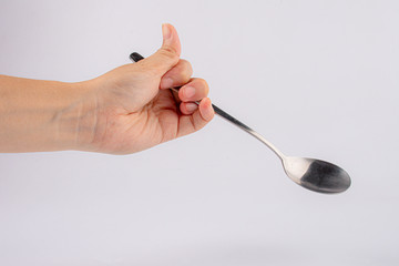 Male hand holding an empty spoon, composition isolated over on the white background