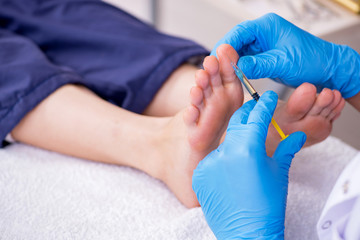 Podiatrist treating feet during procedure