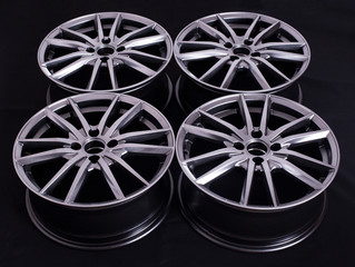 Modern automotive alloy wheel made of aluminum on a black background, industry. Designer fashion...