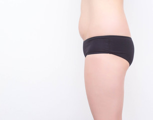 Girl in black shorts with small buttocks on a white background. The concept of buttock augmentation with the help of implants, white background, copy space, healthy