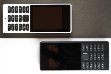 Old cell phones on black and white background.