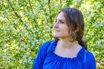 Fototapeta premium Portrait woman in cherry flowers on a green background