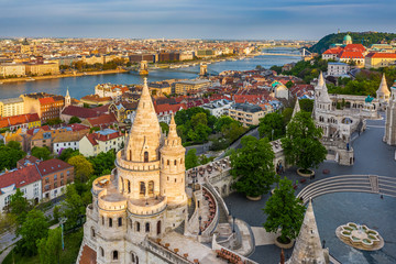 Naklejka premium Budapest, Hungary - Aerial view of the famous Fisherman's Bastion at sunset with Szechenyi Chain Bridge, St.Stephen's Basilica and Buda Castle Royal Palace at background on a sunny summer afternoon